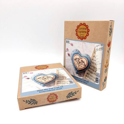 Two cardboard boxes with embroidered heart designs on a white background