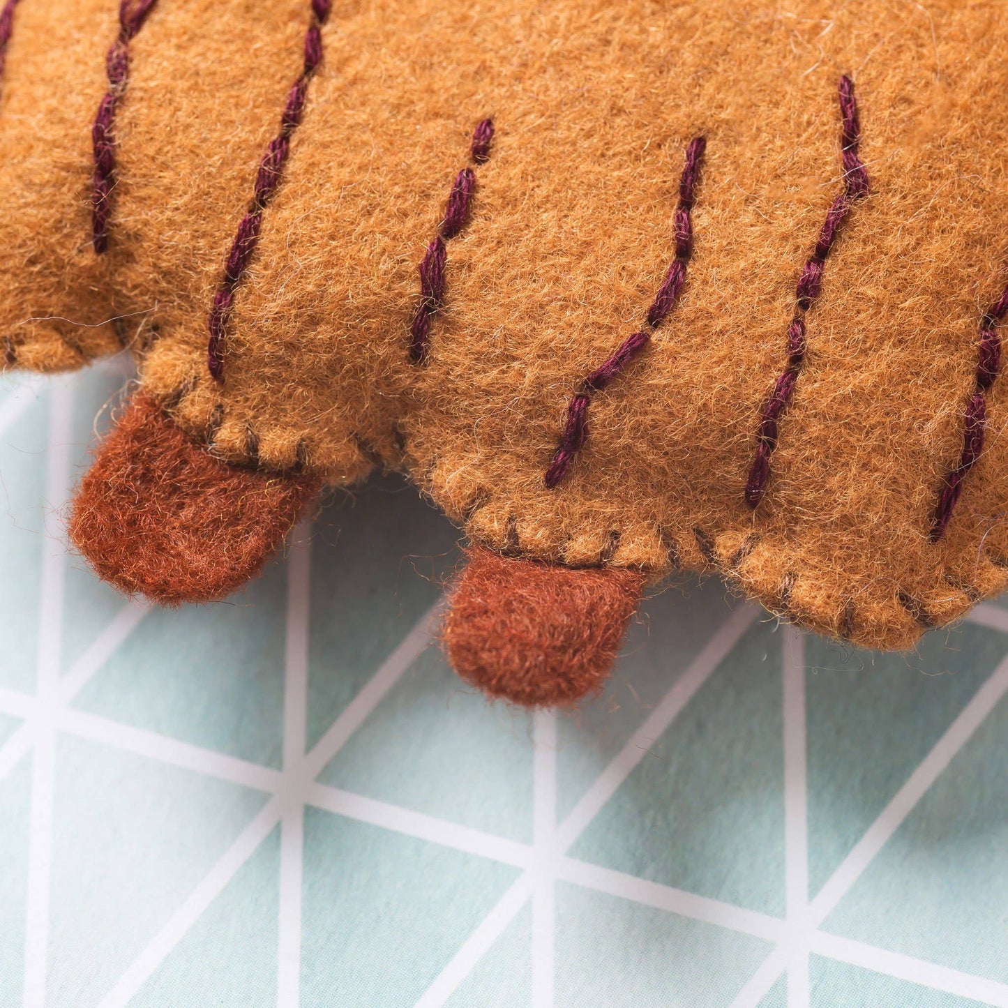 Close-up of a felted highland cow on a grid background