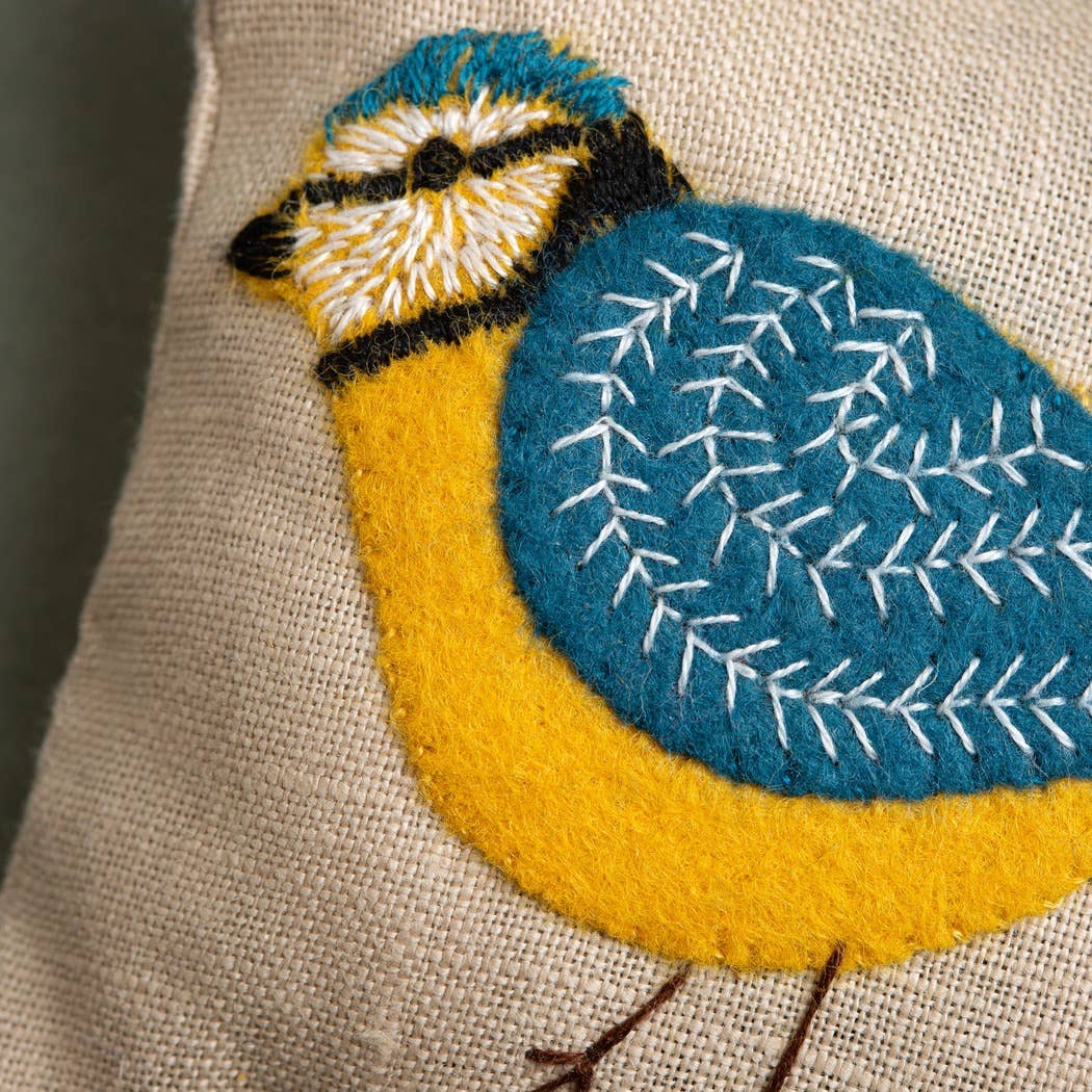 Embroidered bird design on a fabric background