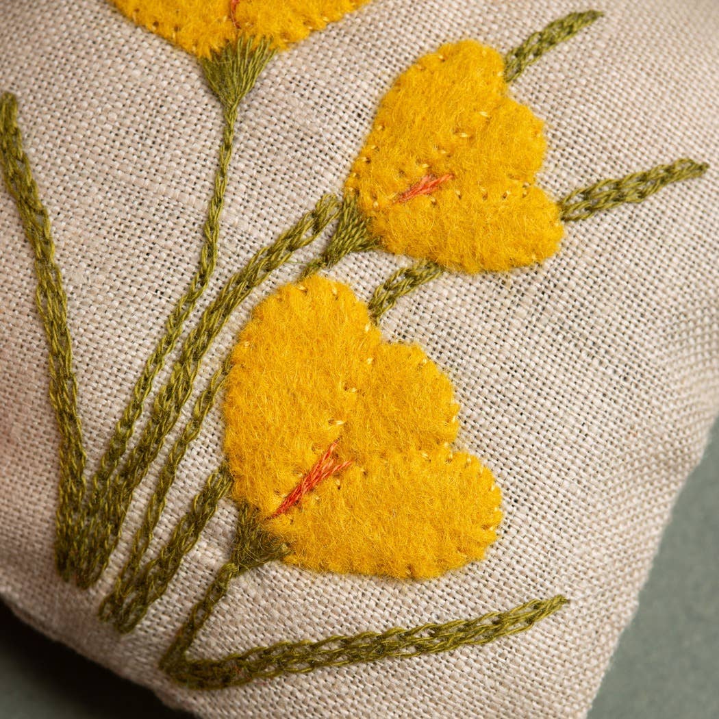 Embroidered yellow flowers on a beige fabric background