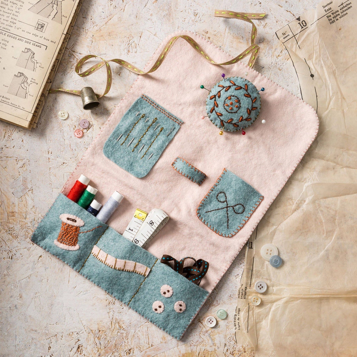 Felt sewing kit with various tools on a textured surface