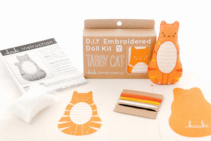 DIY Embroidered Doll Kit with materials and instructions on a white background