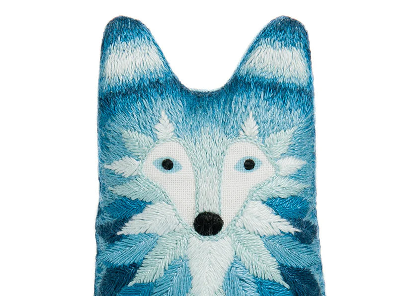 Blue and white fox-shaped plush toy on a white background